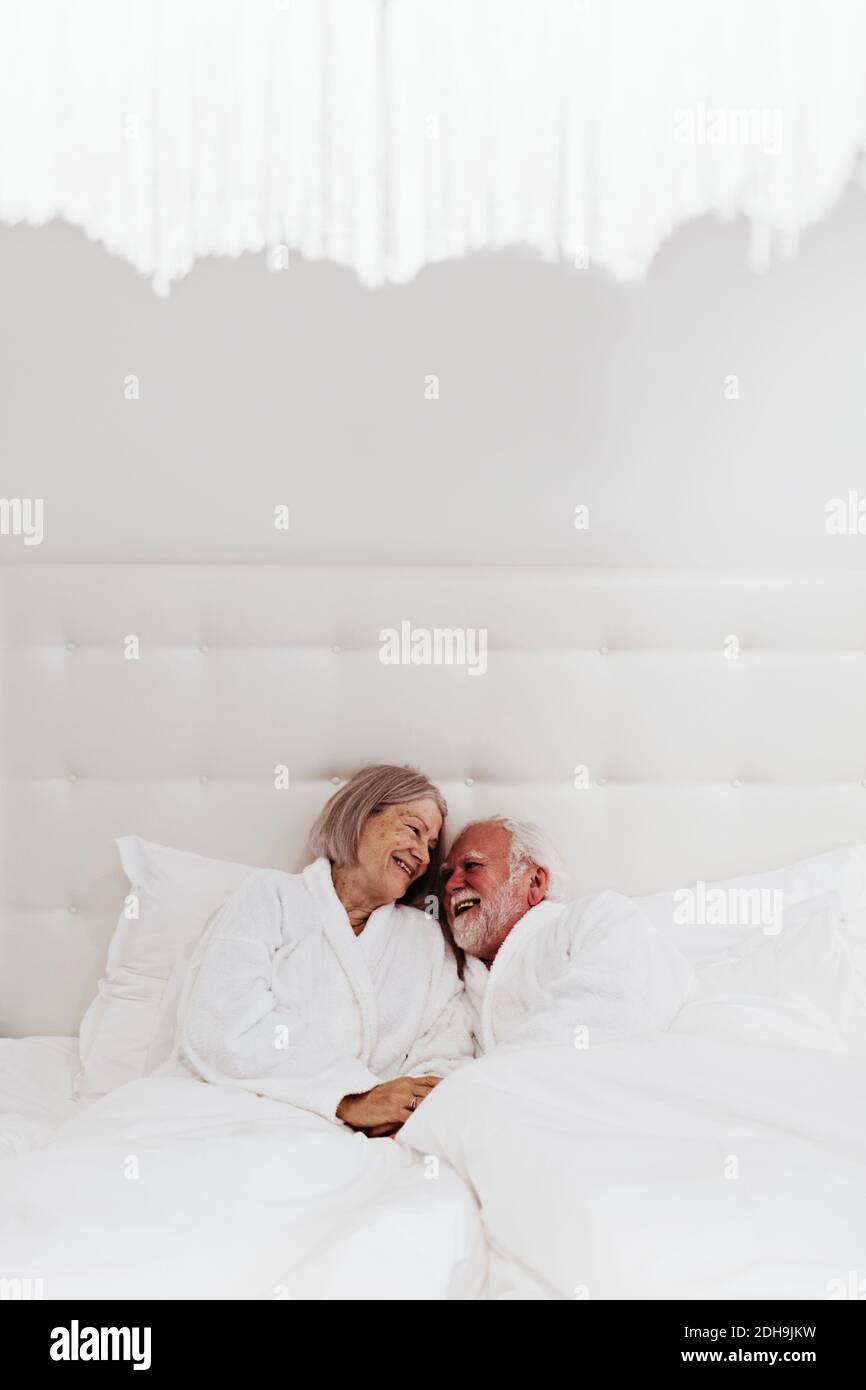 Felice romantica coppia senior a letto in camera d'albergo Foto Stock