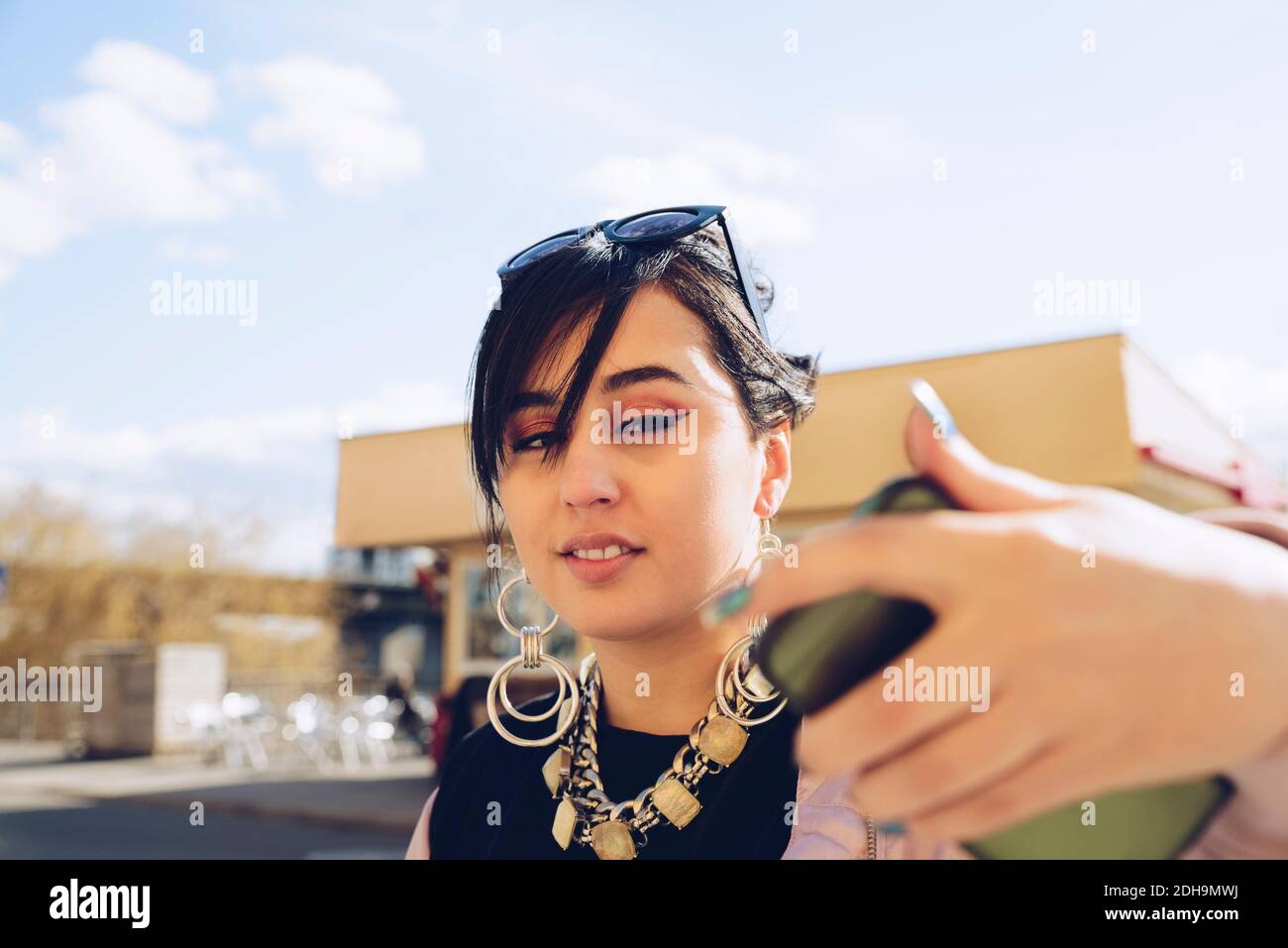 Giovane donna che prende selfie con smartphone in città Foto Stock
