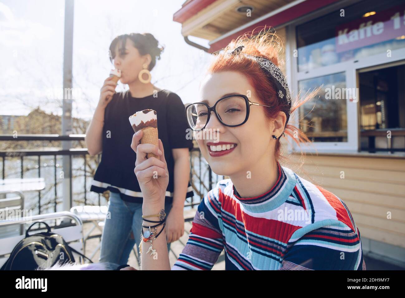 Hipster femmina amici mangiare gelato da negozio Foto Stock