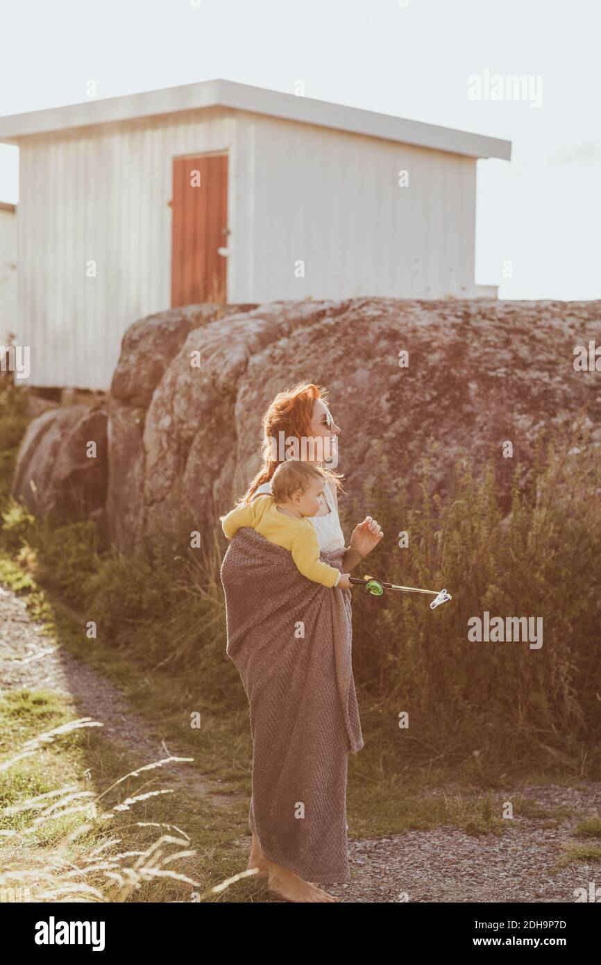 Madre con bambina che guarda via mentre si sta in piedi dalla roccia formazione Foto Stock