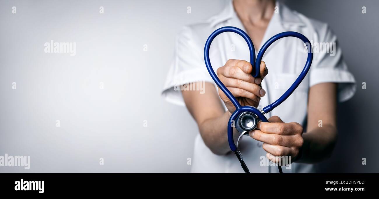 medico femminile con stetoscopio a forma di cuore. amore di lavoro sanitario, cardiologia o concetto di assicurazione sanitaria. copia spazio Foto Stock