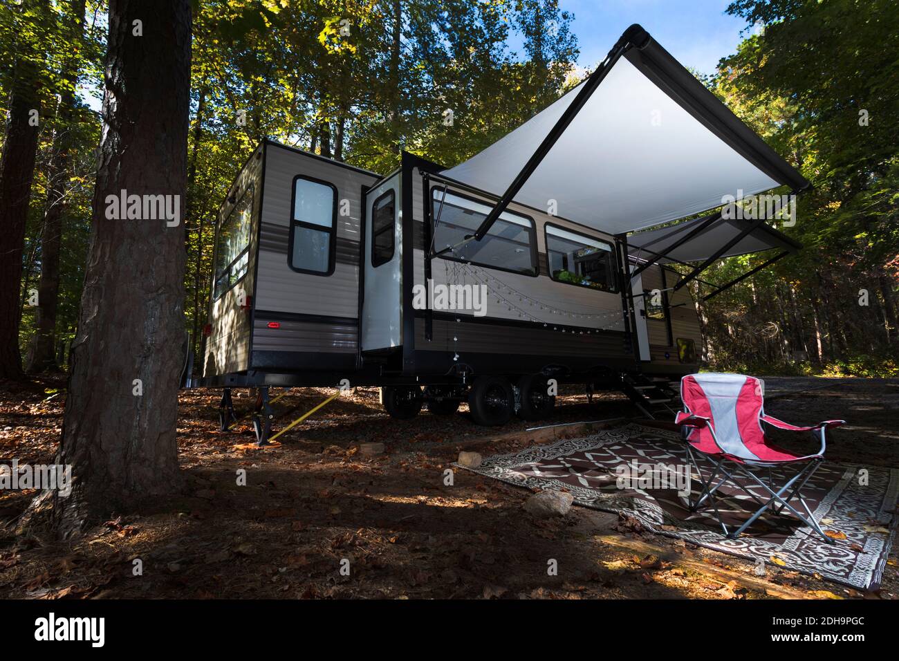 Sentiero per camper all'inizio dell'autunno con una sola sedia vuota in attesa all'esterno Foto Stock