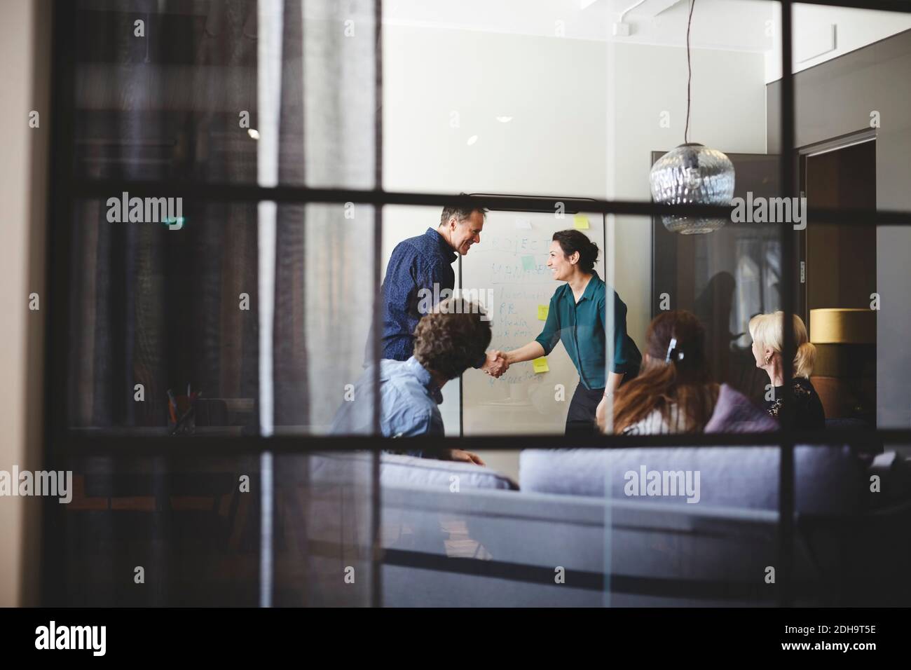 Il team di lavoro nella sala riunioni visto dal vetro alla creatività ufficio Foto Stock