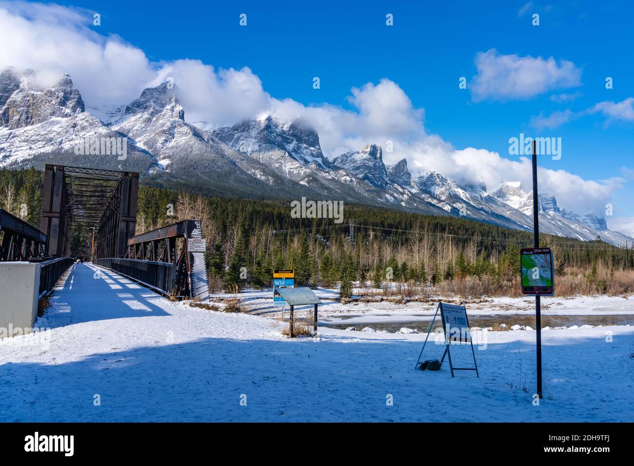 Canmore Engine Bridge nelle prime stagioni invernali giorno di sole mattina. Drift ghiaccio galleggiante sul fiume Bow. Cielo blu chiaro, neve coperto Monte Rundle Foto Stock