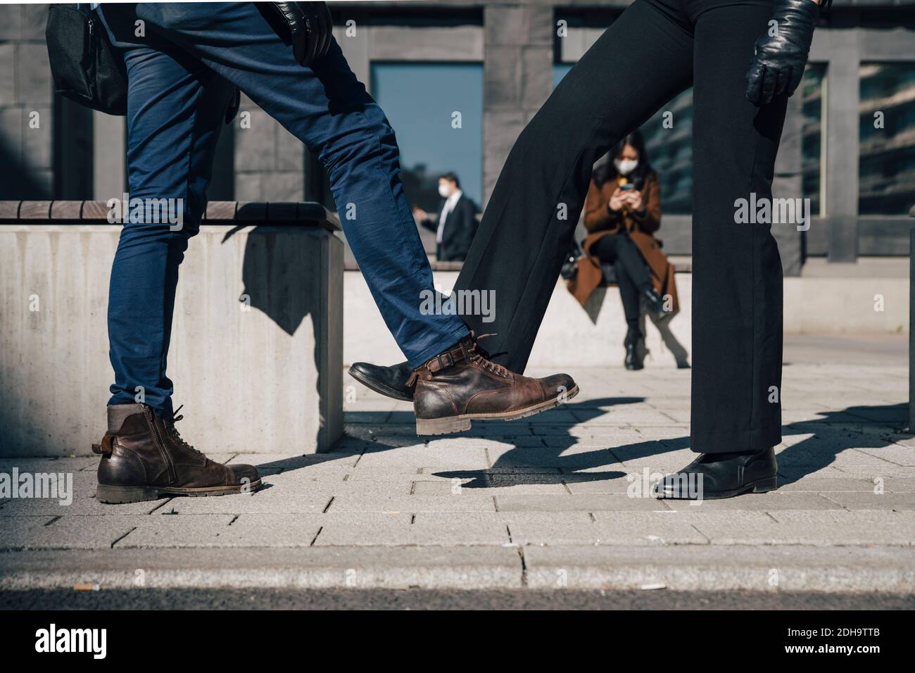 Due persone salutano con i piedi durante la pandemia Foto Stock