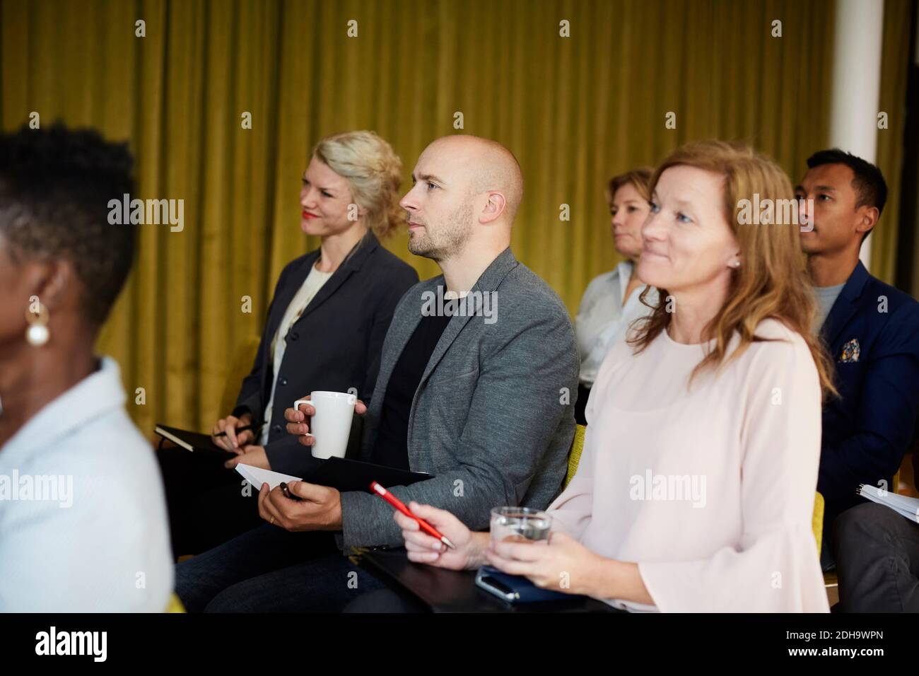 Imprenditori maschili e femminili che si siedono in seminario sul posto di lavoro Foto Stock