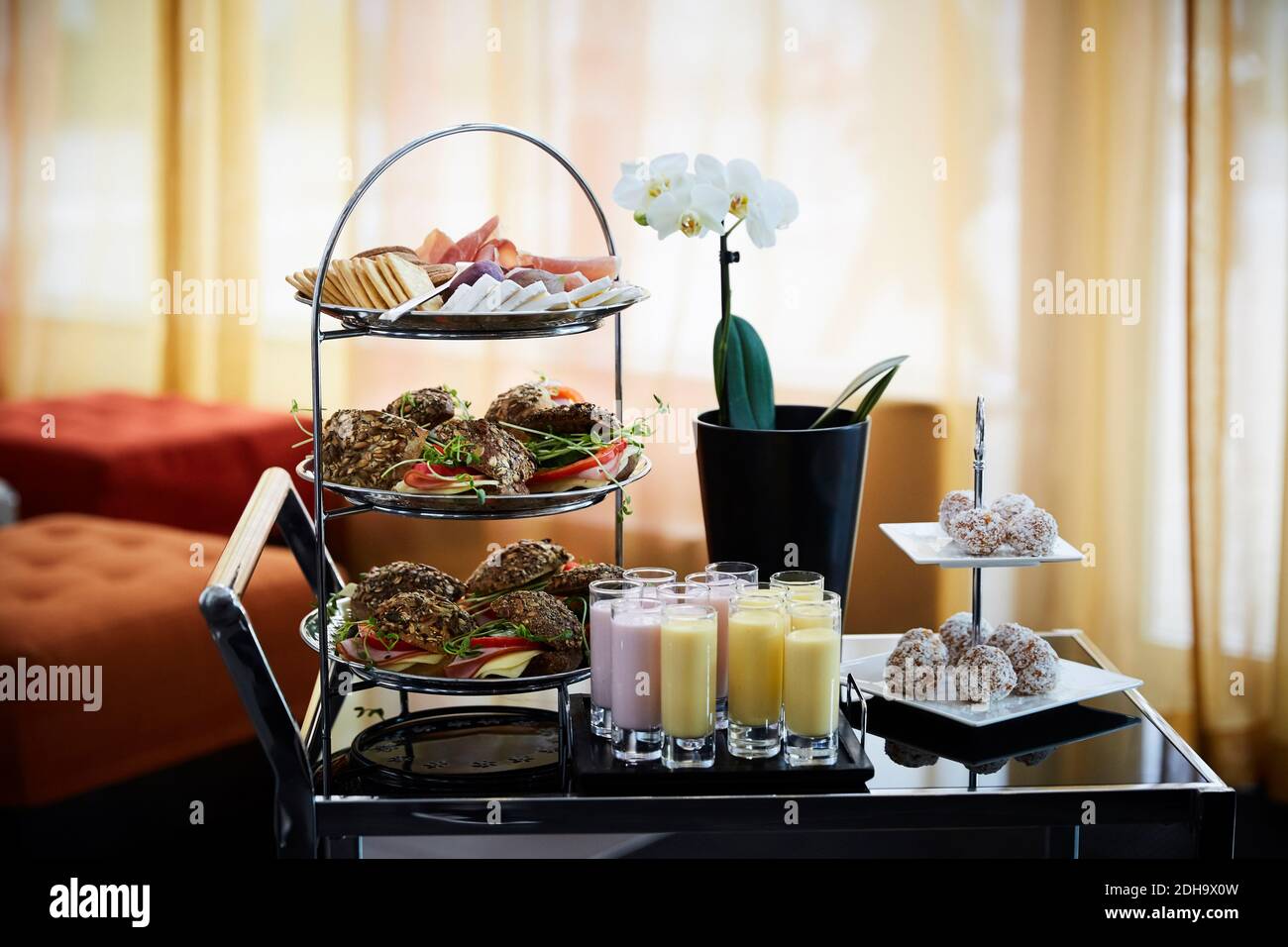Pasto organizzato con vaso di fiori sopra il carrello in ufficio durante seminario Foto Stock