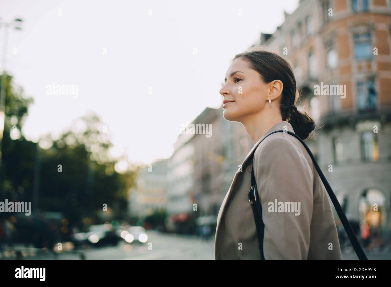 Donna che guarda via durante l'esplorazione della città Foto Stock