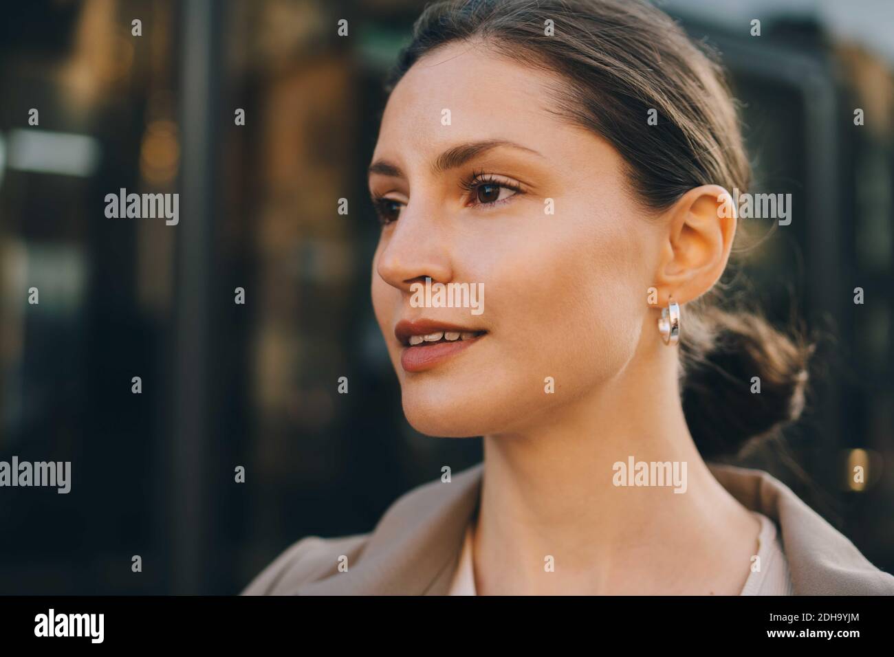 Primo piano di una donna alla moda che guarda lontano in città Foto Stock
