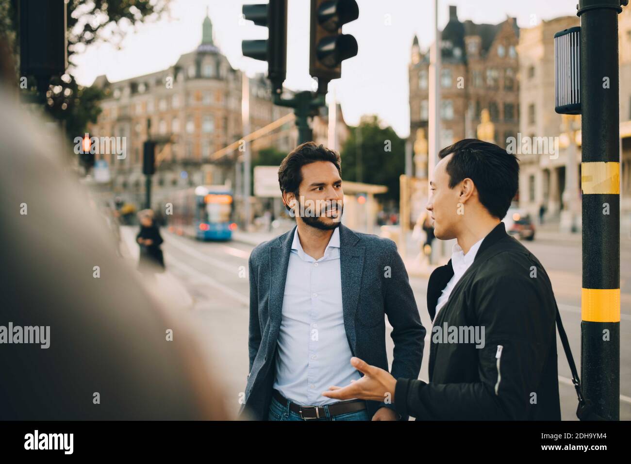 Amici maschi che parlano durante l'esplorazione della città Foto Stock