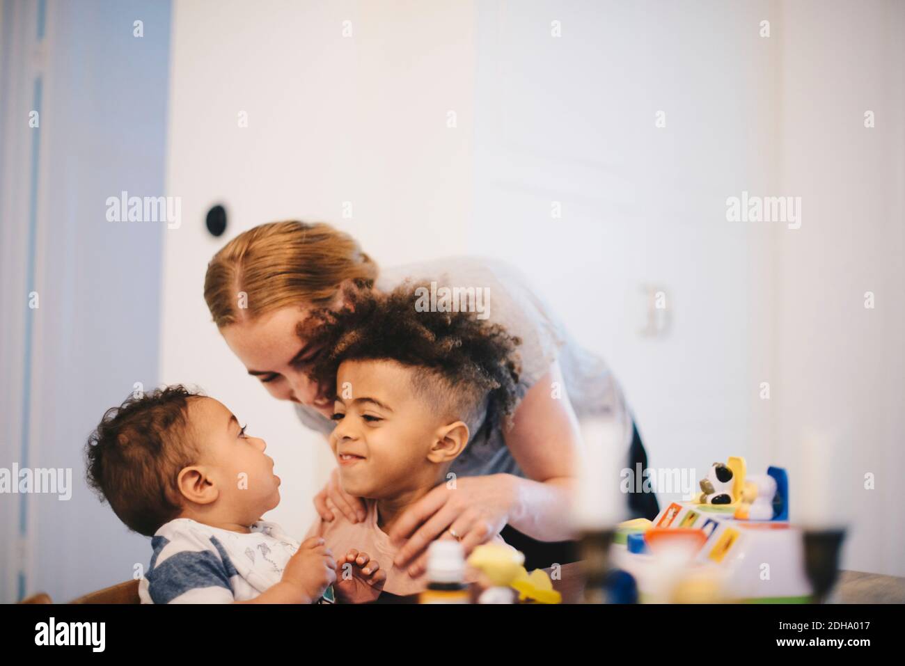 Madre felice abbracciando i figli a casa Foto Stock