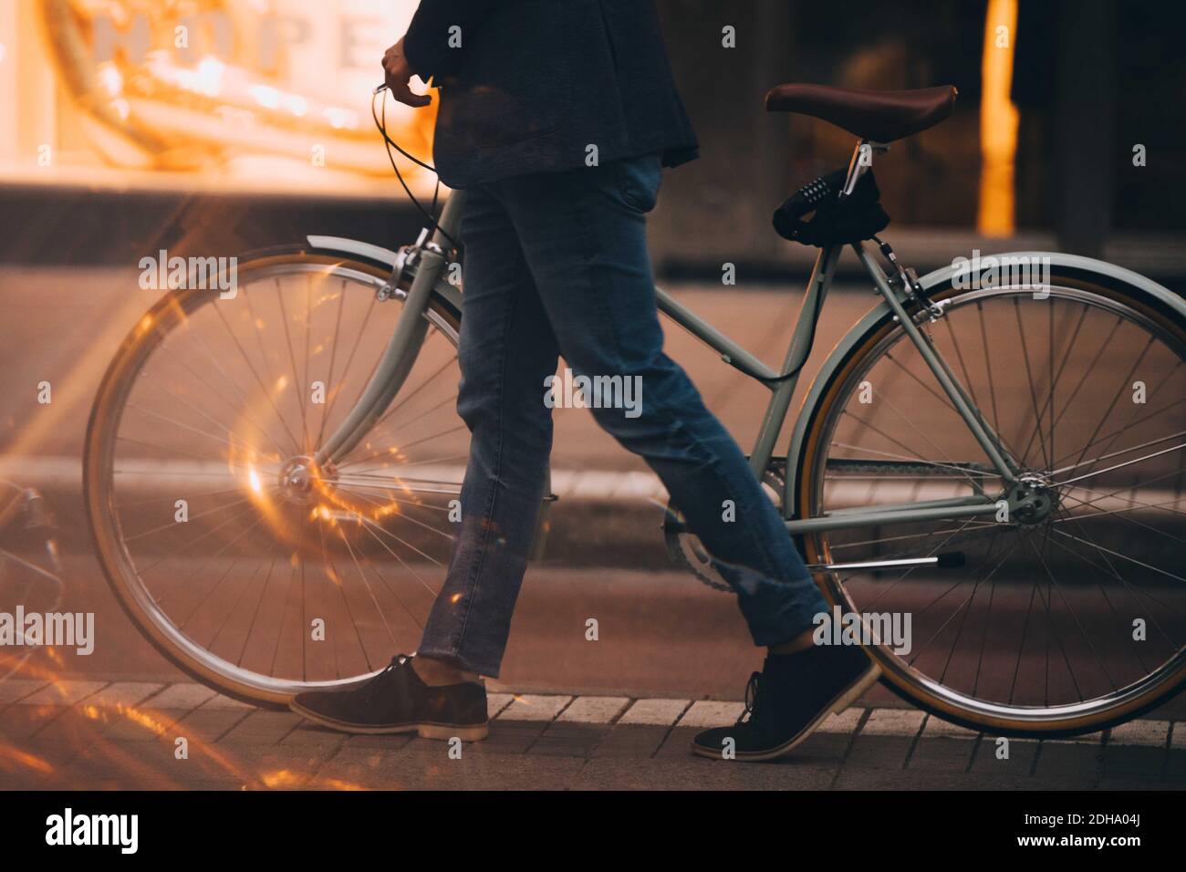 Sezione bassa dell'uomo con passeggiate in bicicletta in città Foto Stock