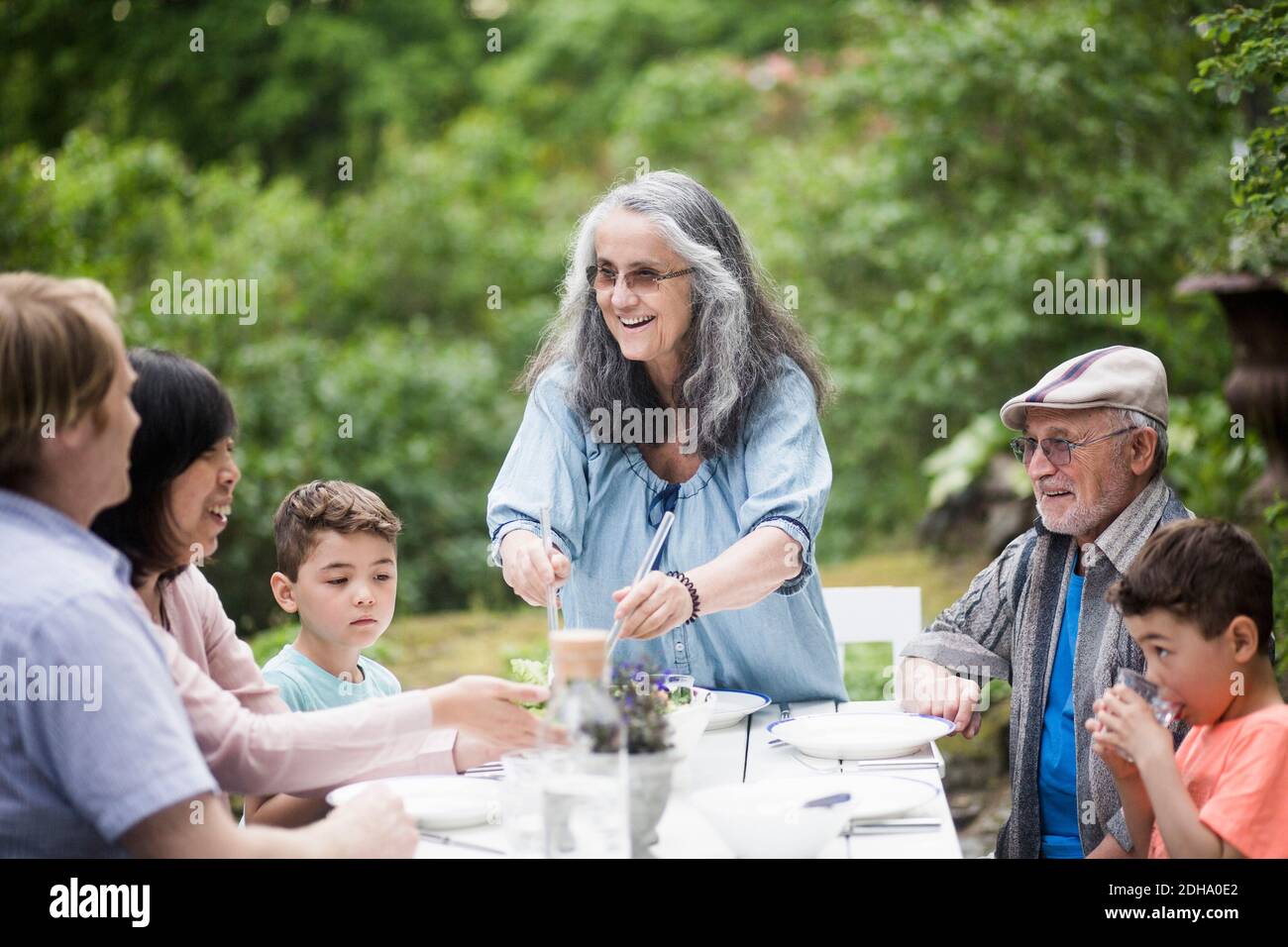 Famiglia multigenerazionale a tavola nel cortile posteriore Foto Stock