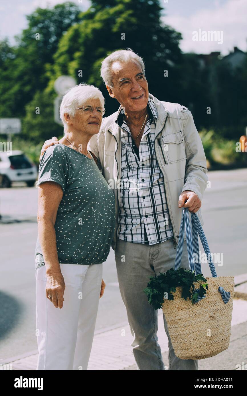 Braccio dell'uomo anziano intorno in piedi con la donna sulla strada dentro città Foto Stock