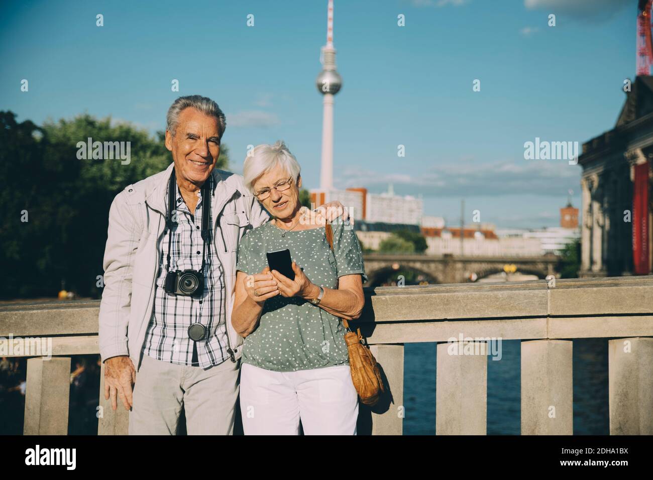 Braccio dell'uomo anziano intorno in piedi con la donna sul ponte dentro città Foto Stock