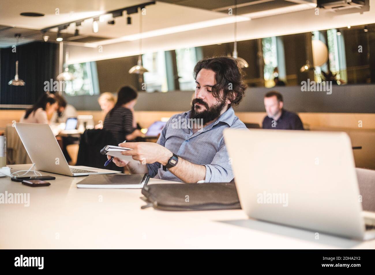 L'imprenditore maschile che pianifica le strategie di affari mentre lavora in ufficio Foto Stock