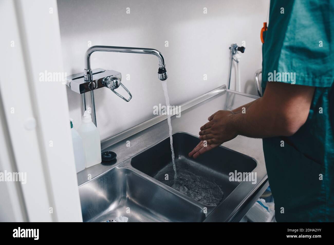 Immagine ritagliata di infermiere maschio che lavano le mani nel lavello a. ospedale Foto Stock Immagine ritagliata di infermiere maschio che lavano le mani nel lavello a. ospedale Foto Stock