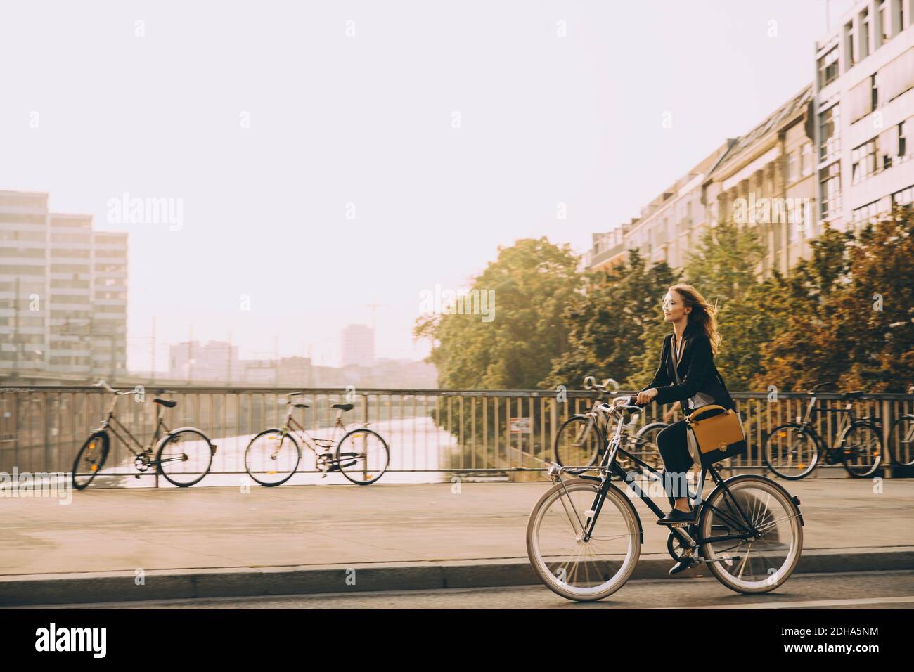 Intera lunghezza della bicicletta da corsa professionale femminile su strada in città contro il cielo Foto Stock
