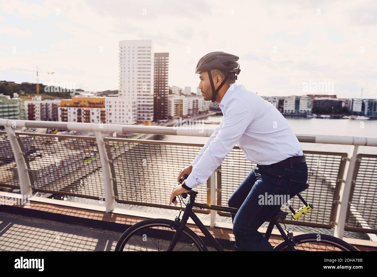 Vista laterale dell'uomo in bicicletta sul ponte pedonale contro il cielo Foto Stock