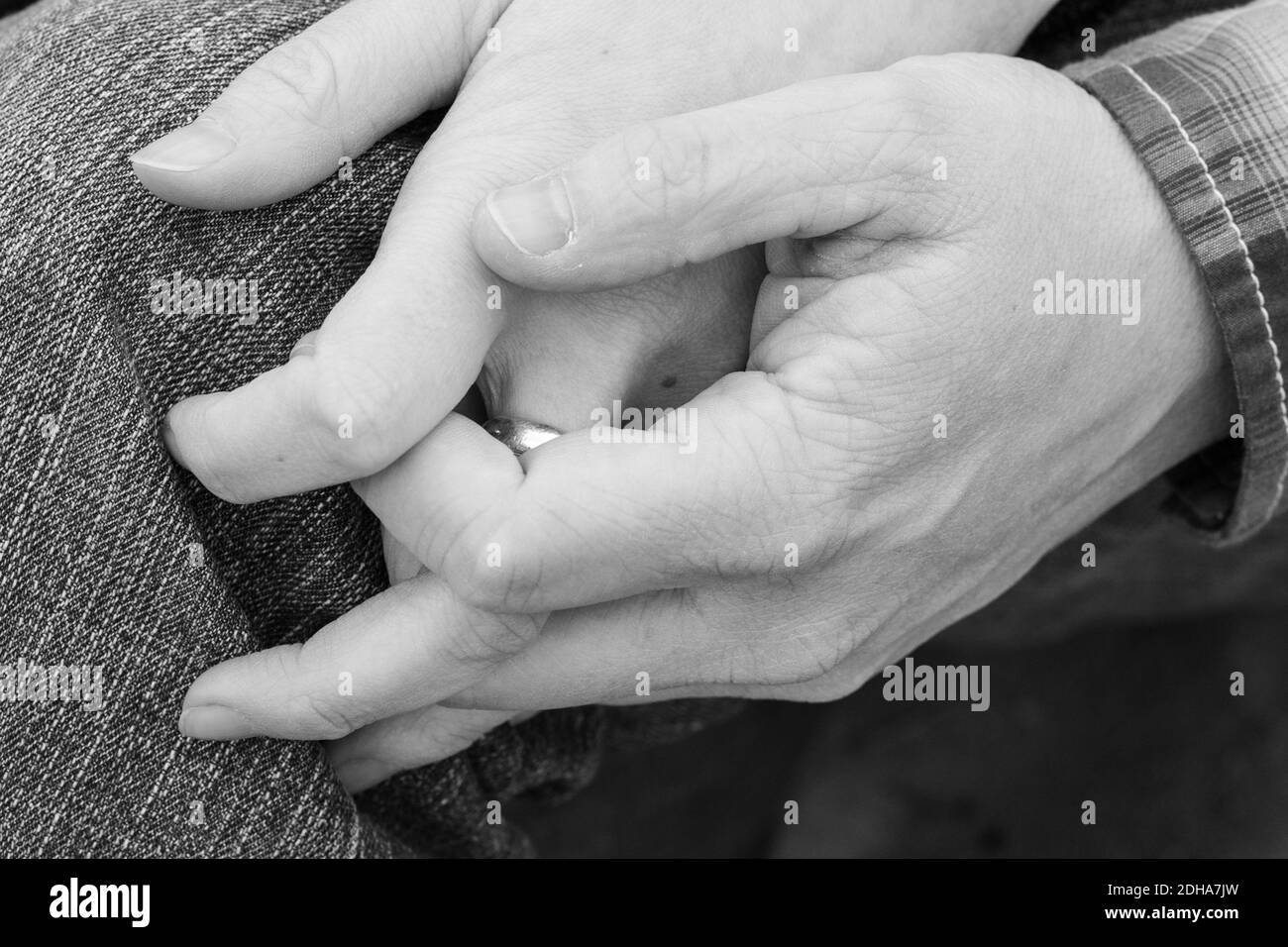 Gli amanti del bianco e del nero tengono le mani in coppia Foto Stock