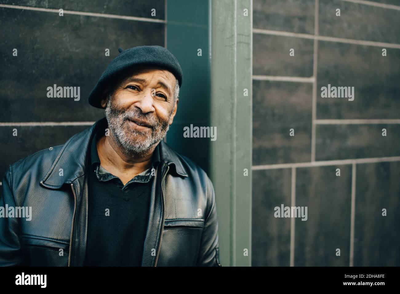 Sorridente uomo anziano contro muro Foto Stock