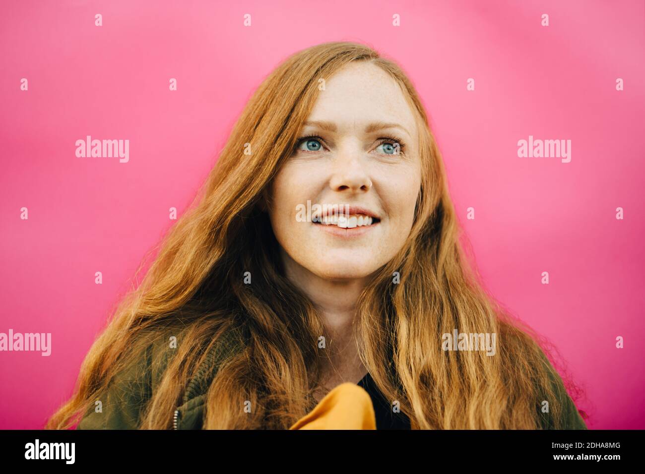 Donna mid adulta sorridente su sfondo rosa Foto Stock