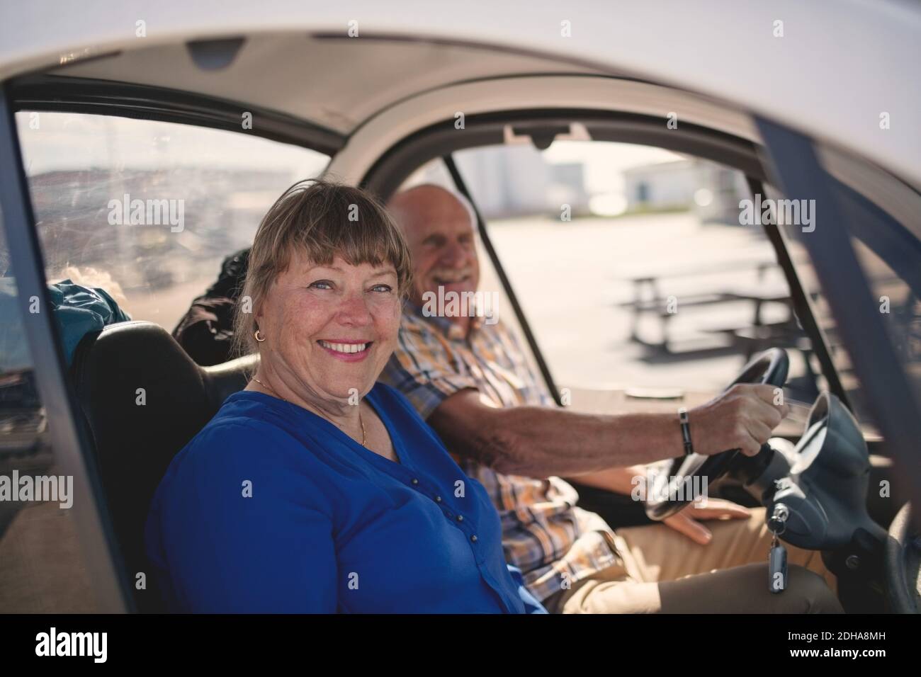 Ritratto di donna anziana sorridente e di uomo che gode di un giro in auto il giorno di sole Foto Stock