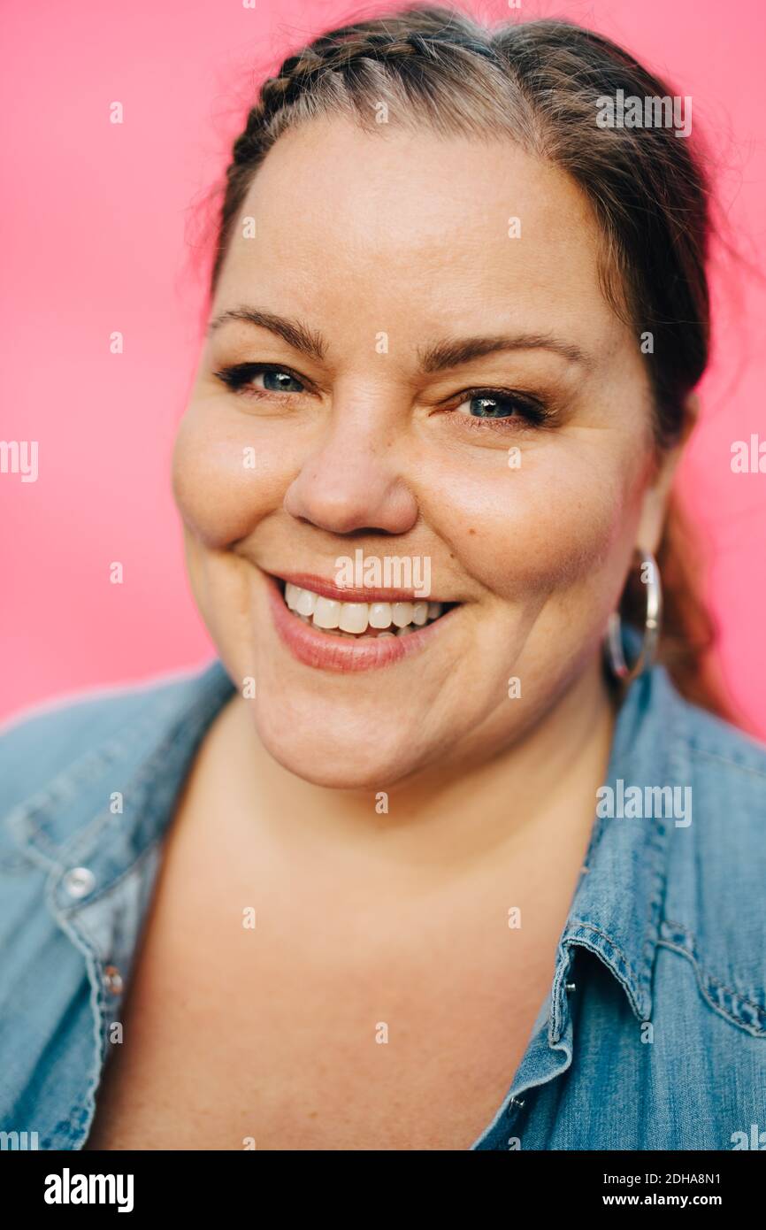 Ritratto di donna matura sorridente su sfondo rosa Foto Stock