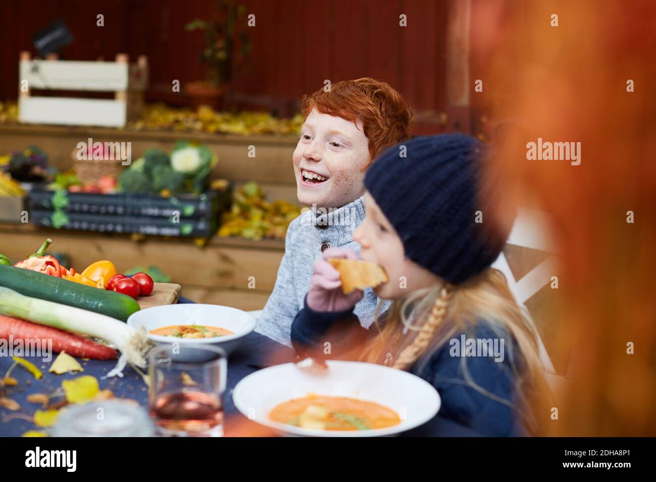 Fratelli e sorelle felici, uomini e donne, seduti a tavola per il pasto Foto Stock