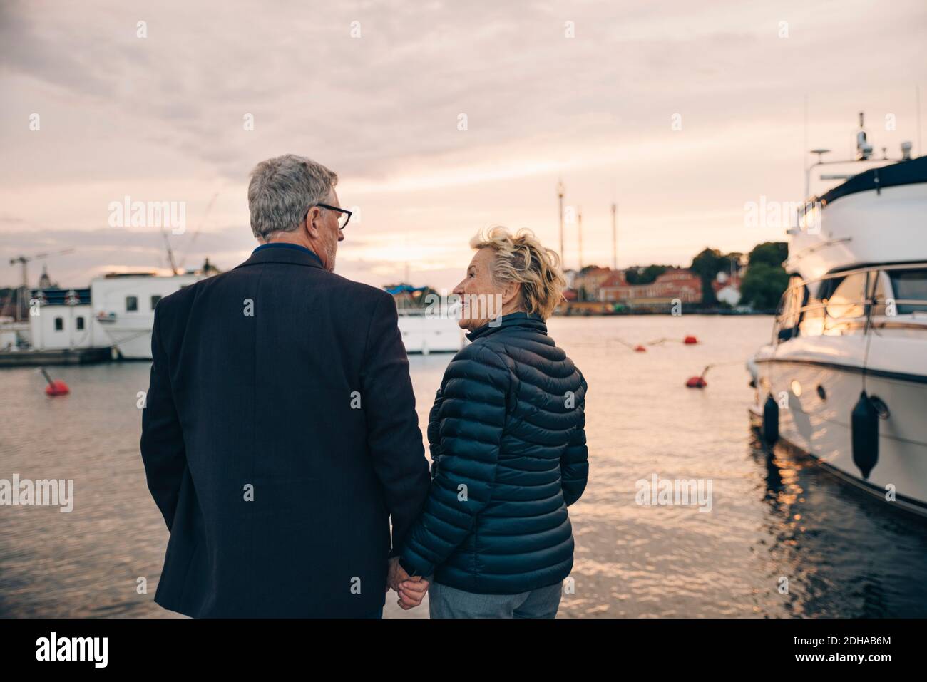 Vista posteriore di uomo anziano e donna che comunica al porto Foto Stock