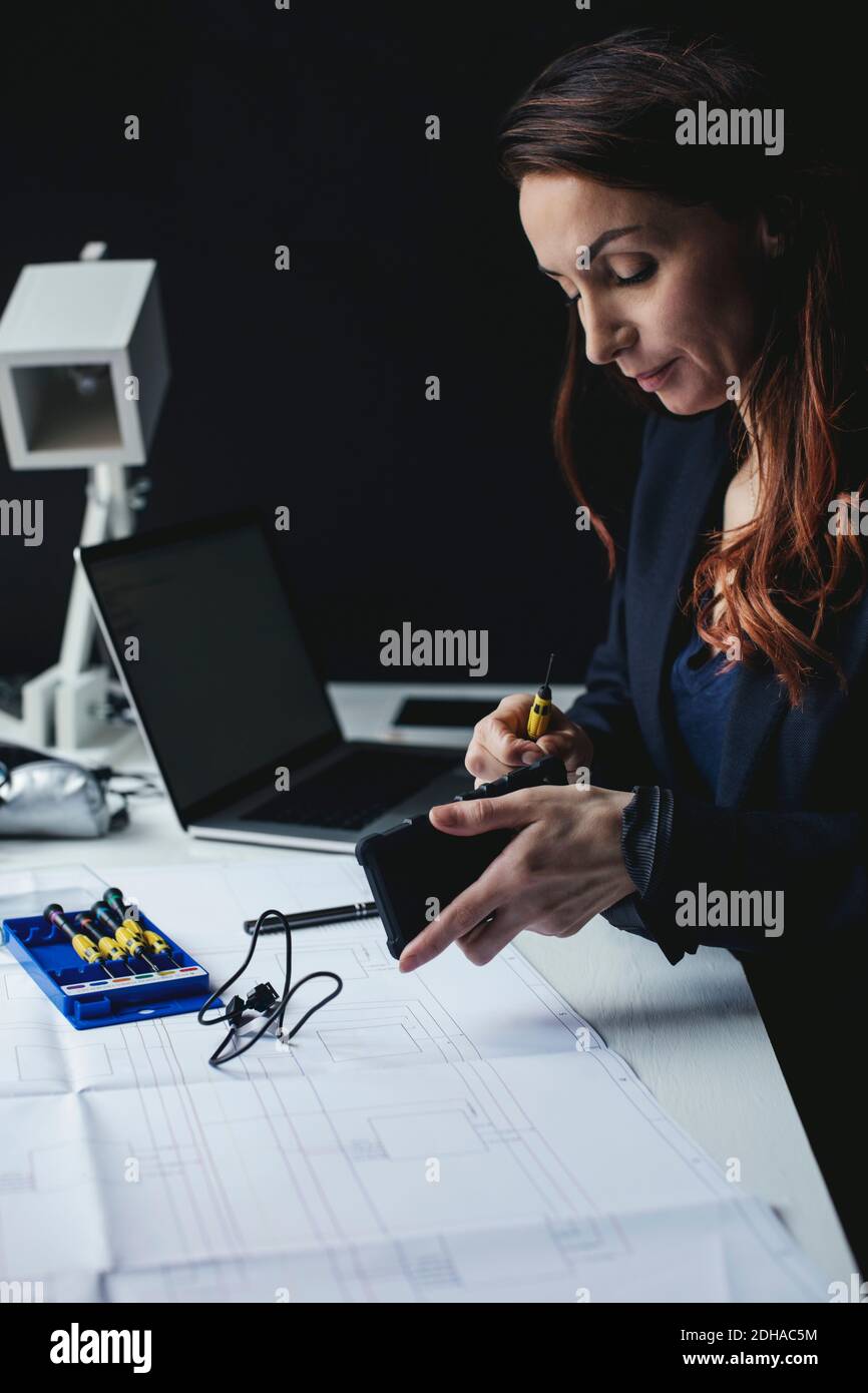 Donna d'affari che lavora su un disco rigido portatile alla scrivania ufficio domestico Foto Stock