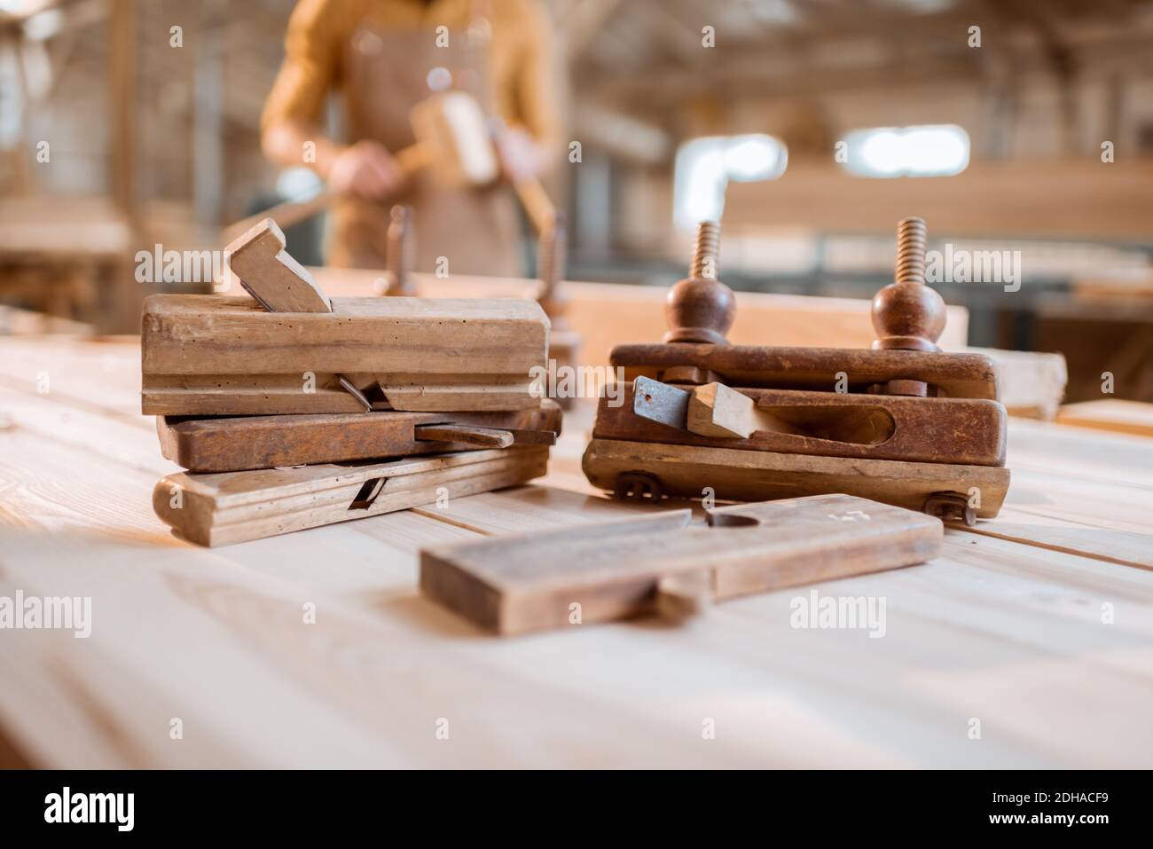 Banco da lavoro con vecchi attrezzi vintage di carpenteria e falegname sul sfondo nel negozio Foto Stock