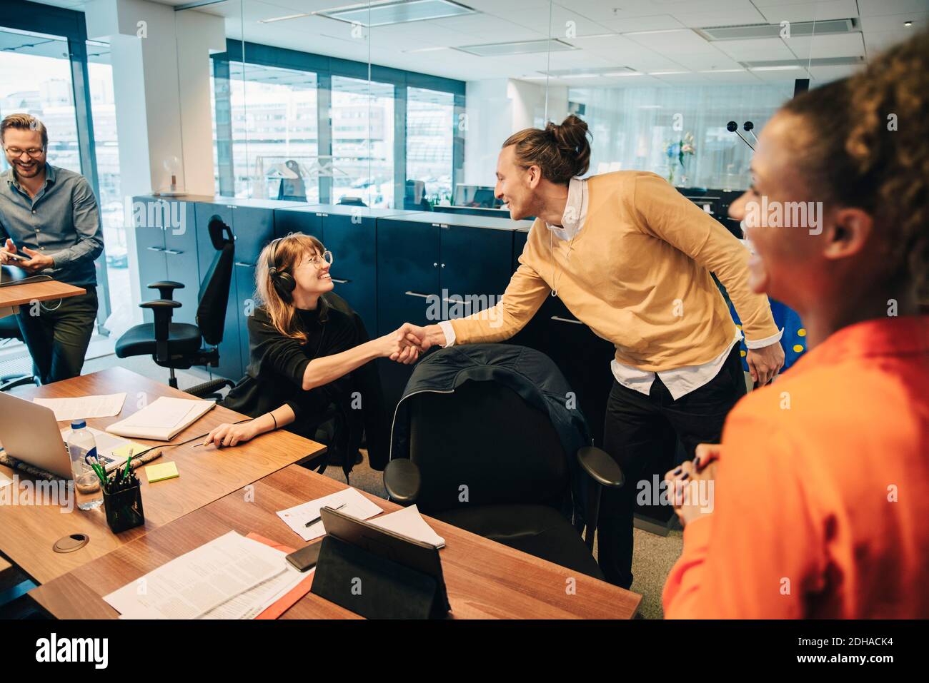 Felice i colleghi si stringono la mano in ufficio Foto Stock