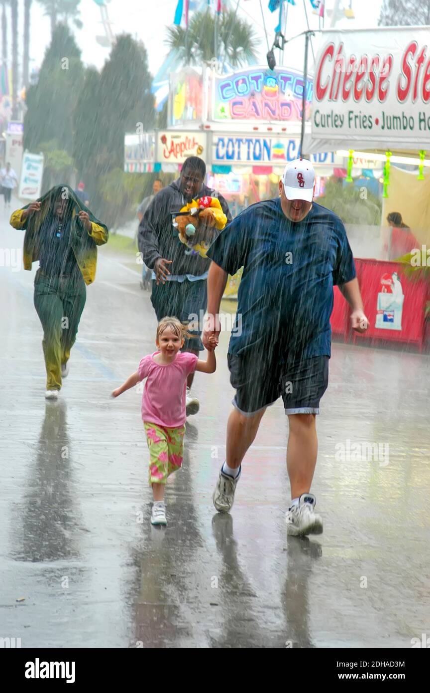 Corsa per coprire durante la tempesta della pioggia Florida state Fair Tampa FL Foto Stock