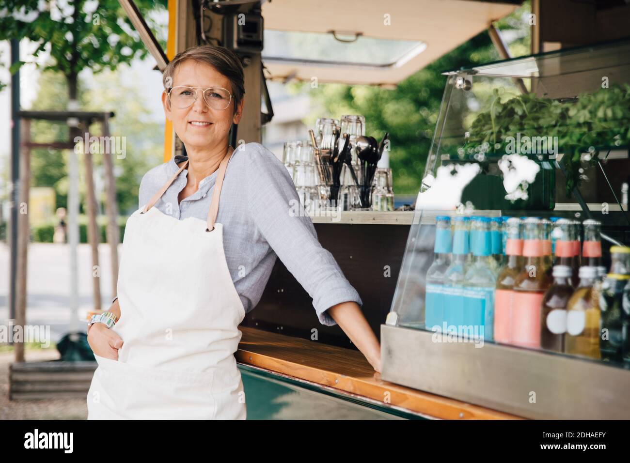 Ritratto di donna matura in piedi su veicolo commerciale di terra Foto Stock