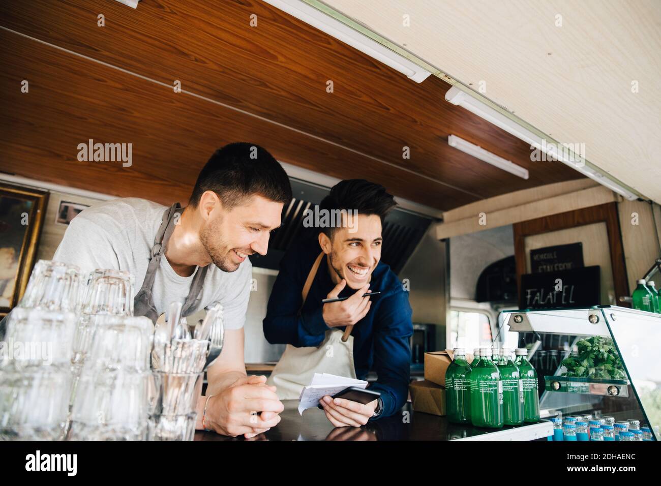 Felici colleghi di sesso maschile in piedi in un veicolo commerciale di terra Foto Stock
