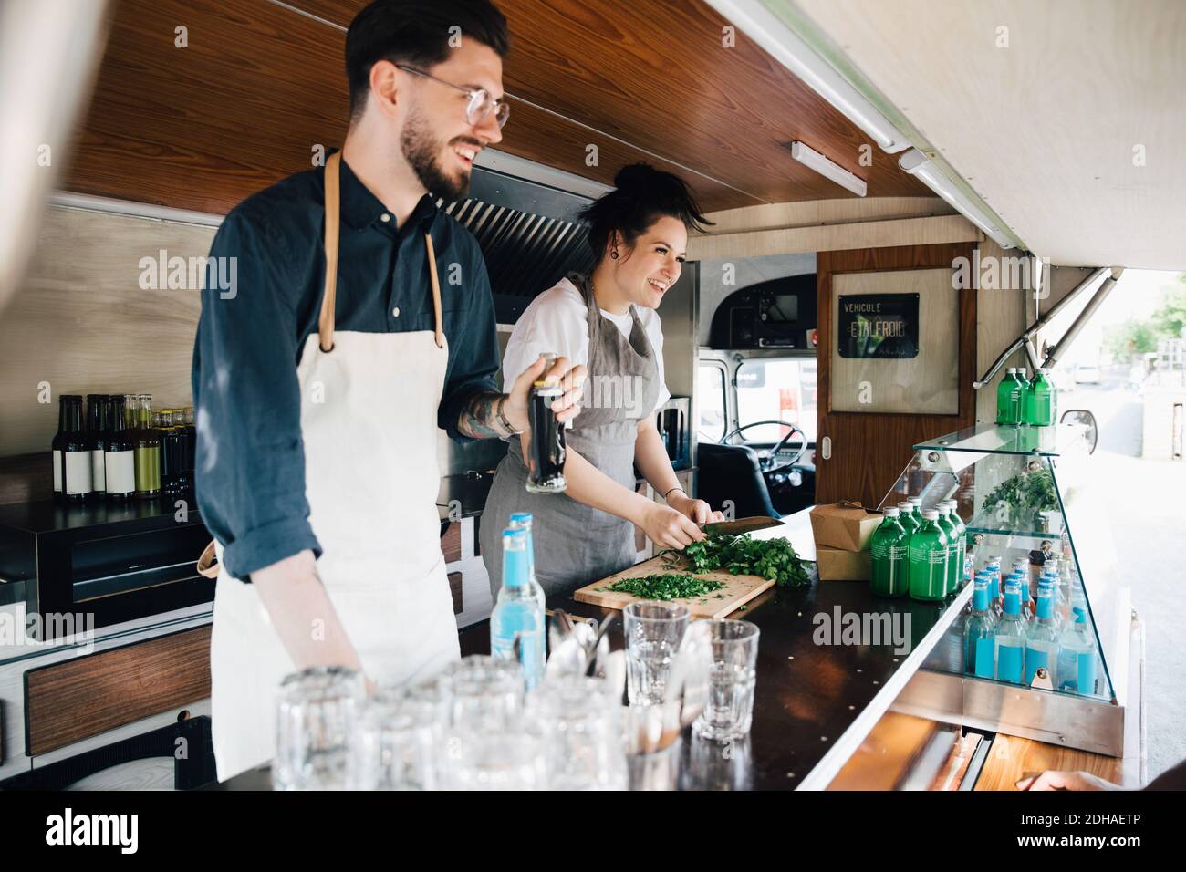 Donna sorridente che lavora con un collega maschile in terra commerciale veicolo Foto Stock