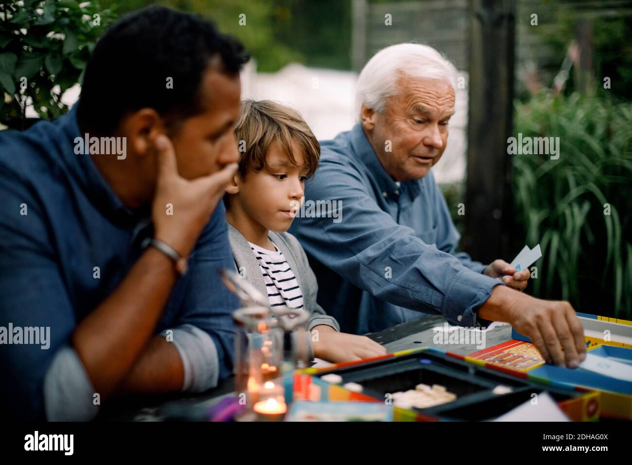 Gioco da tavolo per tutta la famiglia mentre sei seduto al tavolo cortile Foto Stock