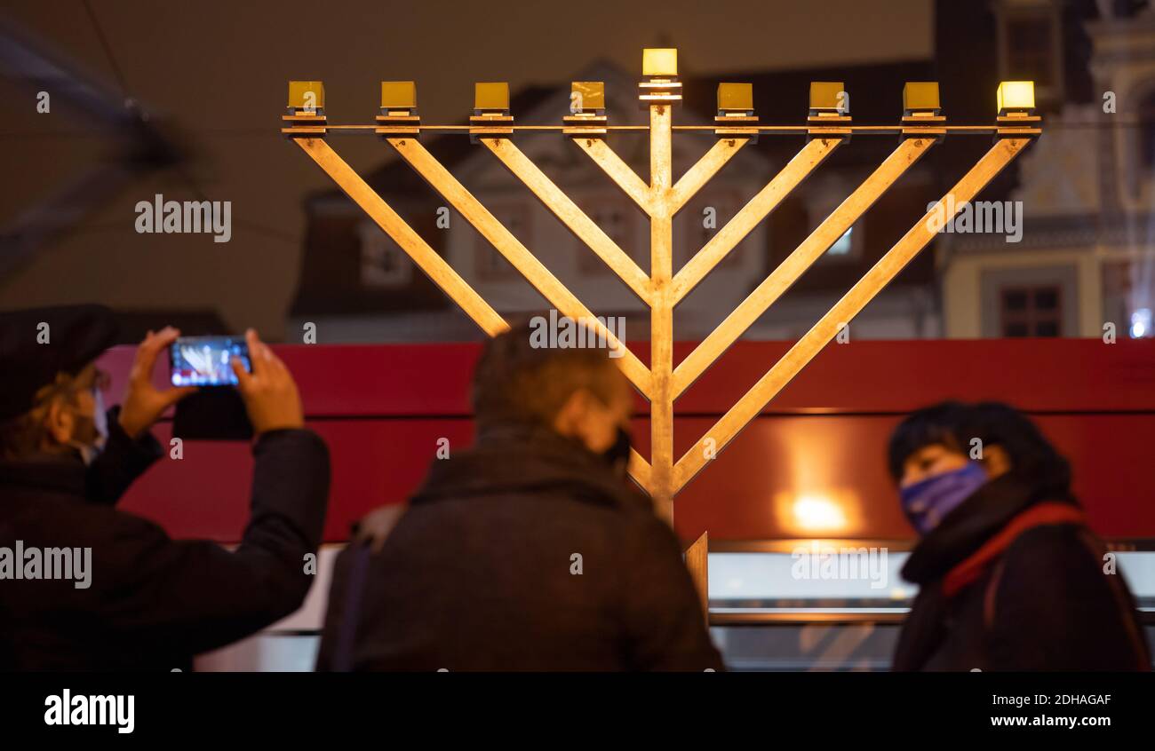 Erfurt, Germania. 10 dicembre 2020. La prima luce del lampadario di Hanukkah di fronte al municipio di Erfurt risplende dopo la sua accensione cerimoniale all'inizio del festival ebraico delle luci. Credit: Michael Reichel/dpa-Zentralbild/dpa/Alamy Live News Foto Stock