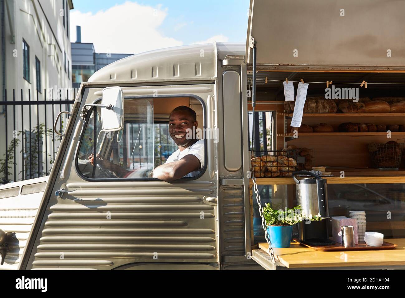 Ritratto di un sorridente venditore seduto in un camion di cibo Foto Stock