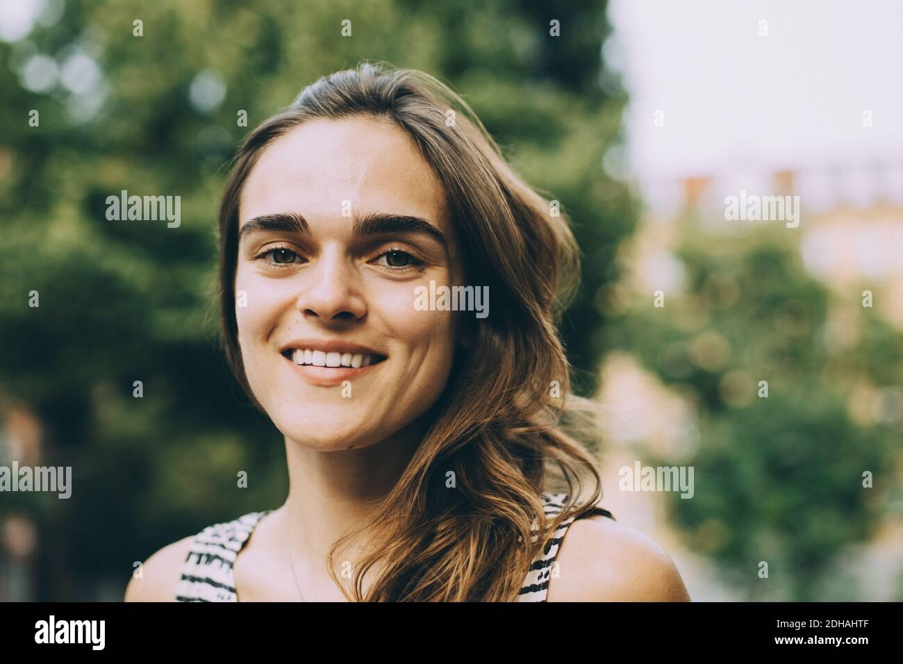 Close-up verticale di sorridere giovane donna con capelli castani Foto Stock