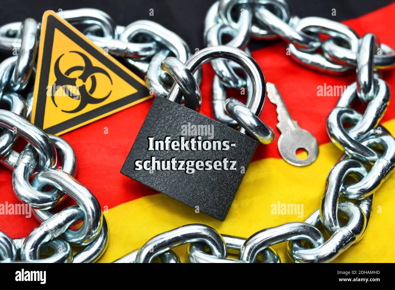 Kontakt, Geschlossenes Vorhängeschloss mit Aufschrift Infektionsschutzgesetz auf Deutschlandfahne Foto Stock