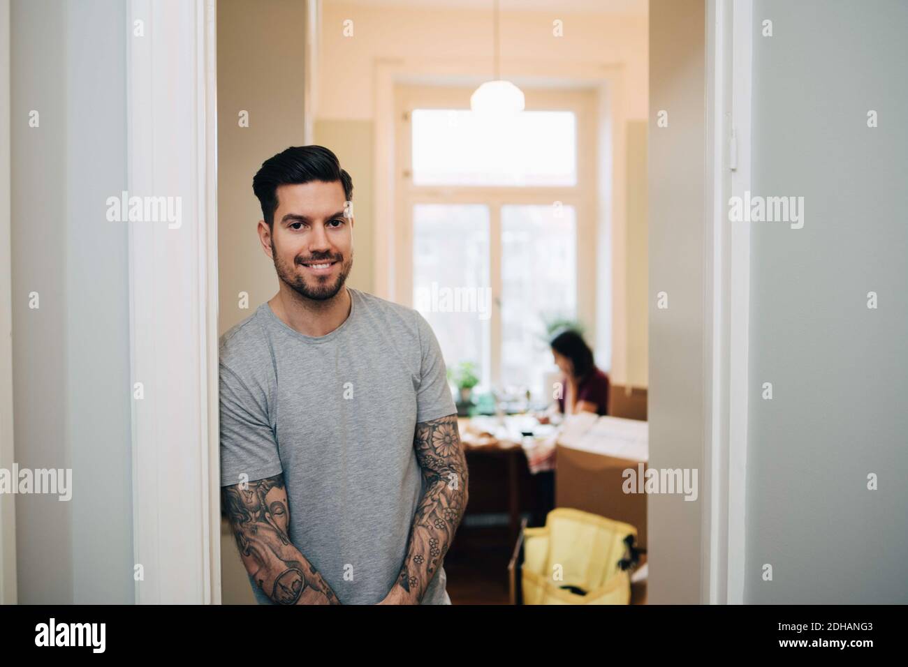 Ritratto di un uomo sorridente appoggiato sulla porta della nuova casa Foto Stock