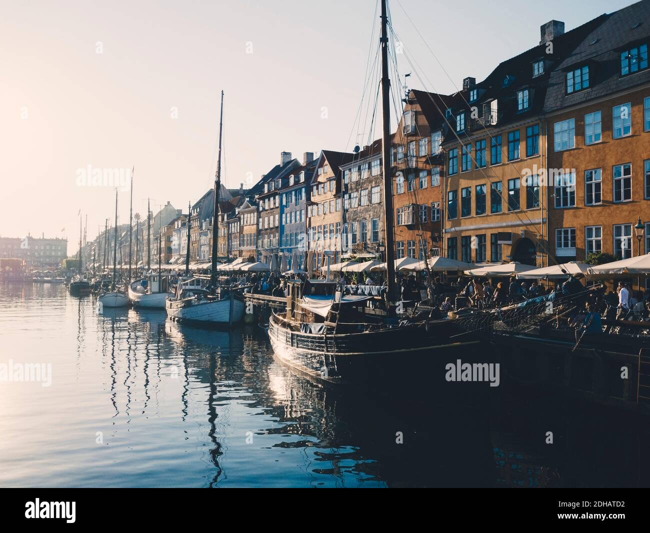 Barche ormeggiate in acqua da edifici in città contro il cielo Foto Stock