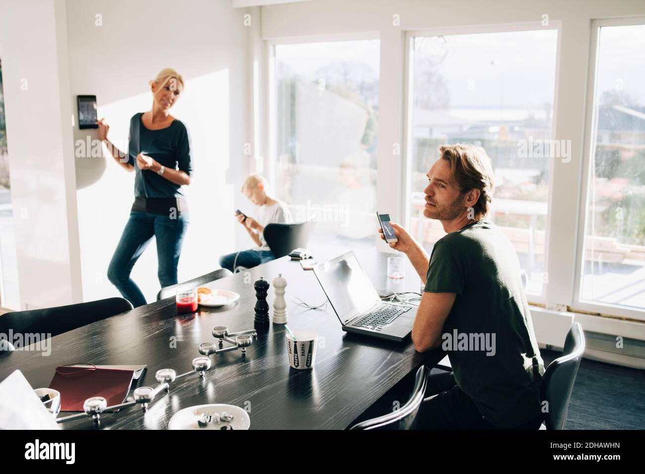 Donna matura in piedi da un figlio che guarda l'uomo in camera Foto Stock