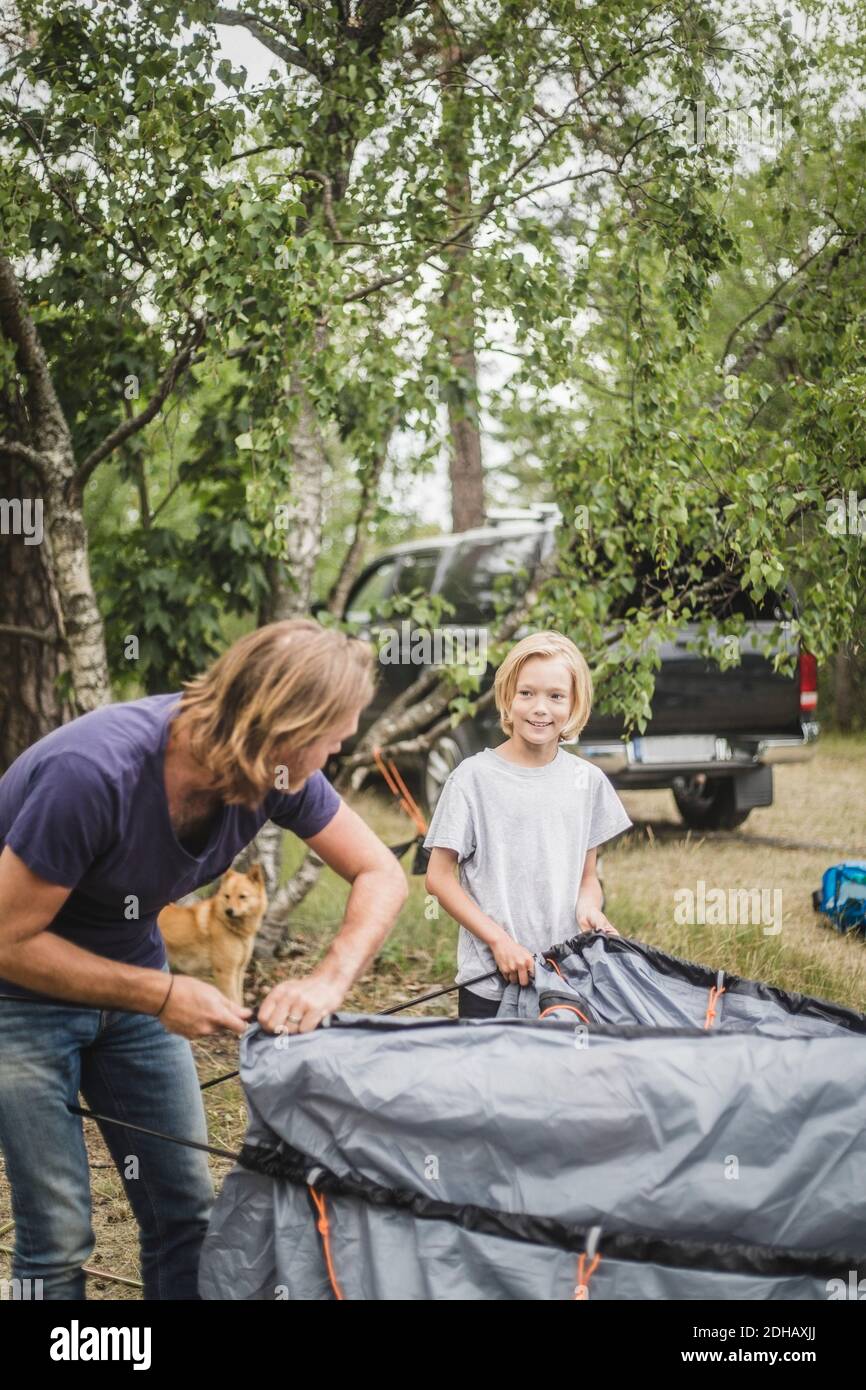 Padre e figlia che parlano mentre pitching tenda al campeggio Foto Stock