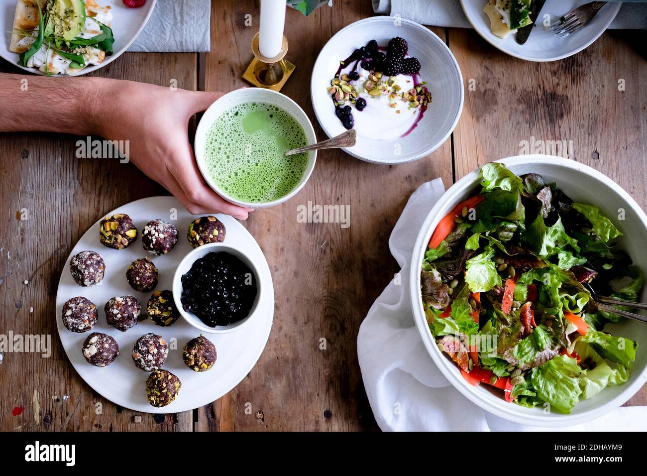 Mano tagliata di uomo che ha tè matcha durante il pasto a. tabella Foto Stock