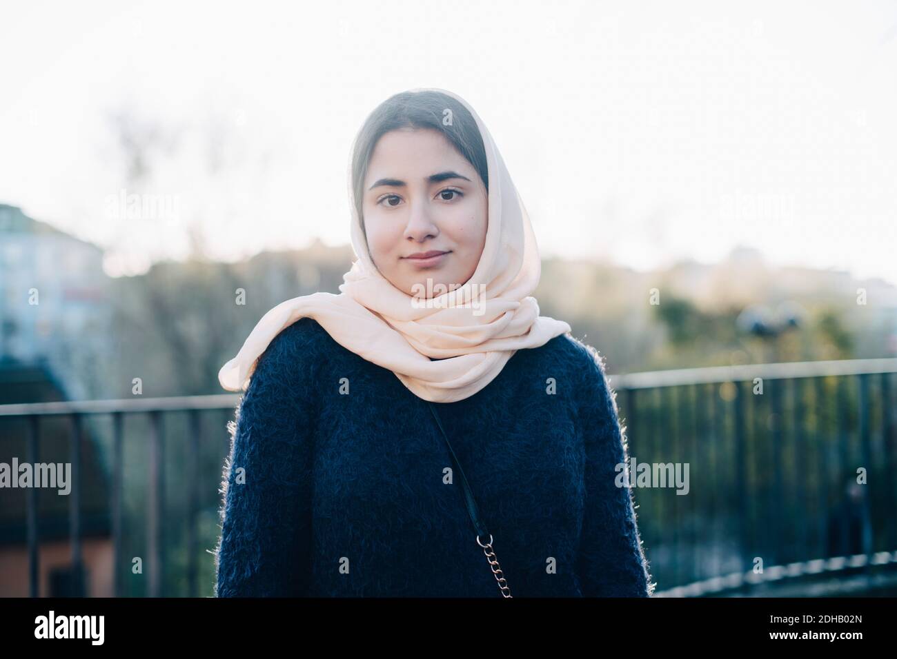 Ritratto di fidata ragazza adolescente che indossa hijab guardando lontano contro cielo Foto Stock