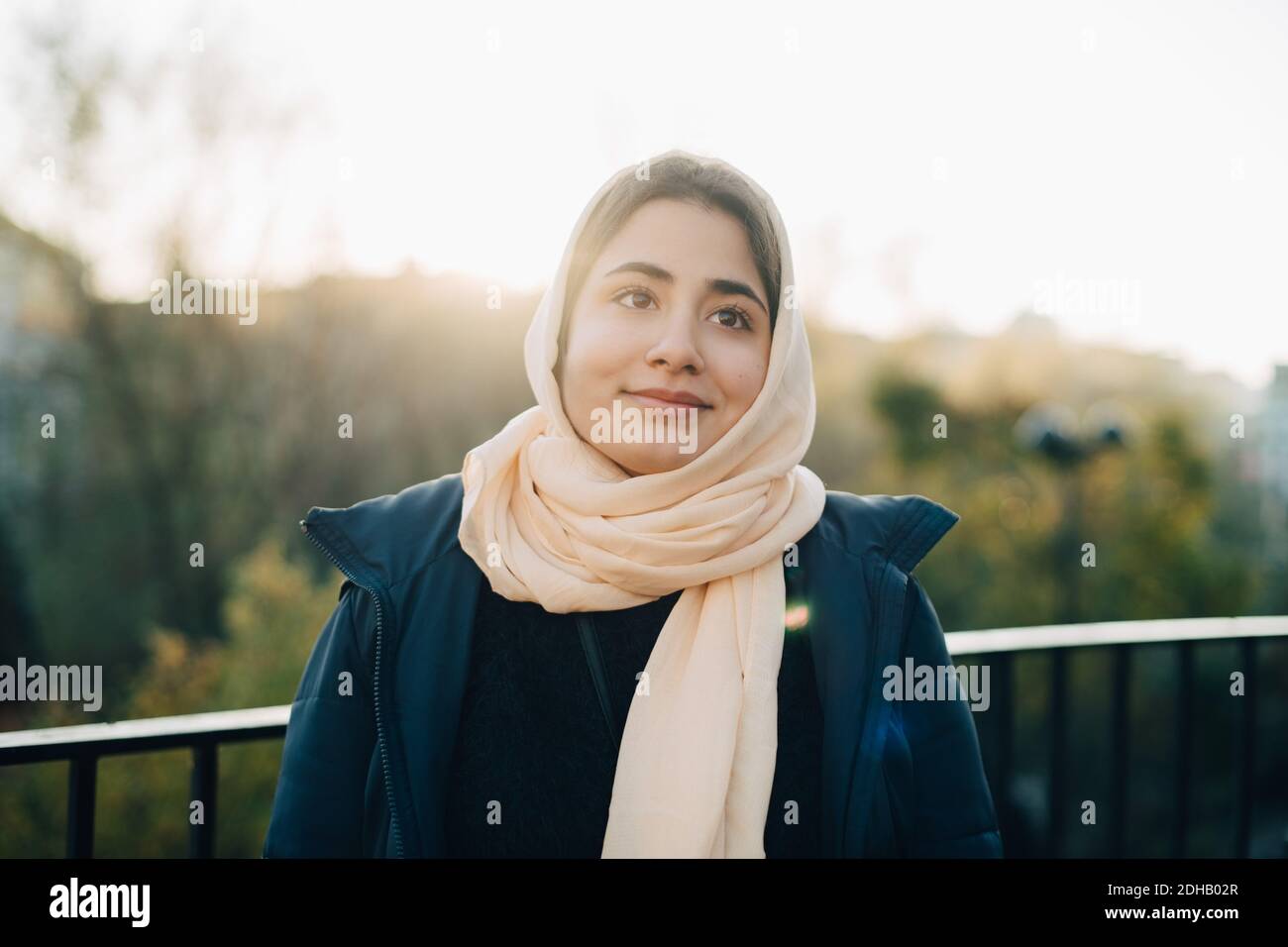 Pensieroso adolescente ragazza che indossa hijab guardando via contro il cielo Foto Stock