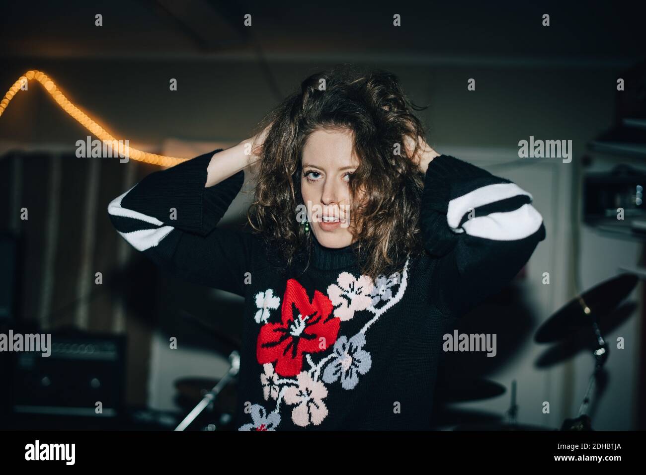 Ritratto di giovane musicista con capelli agili in piedi in studio Foto Stock